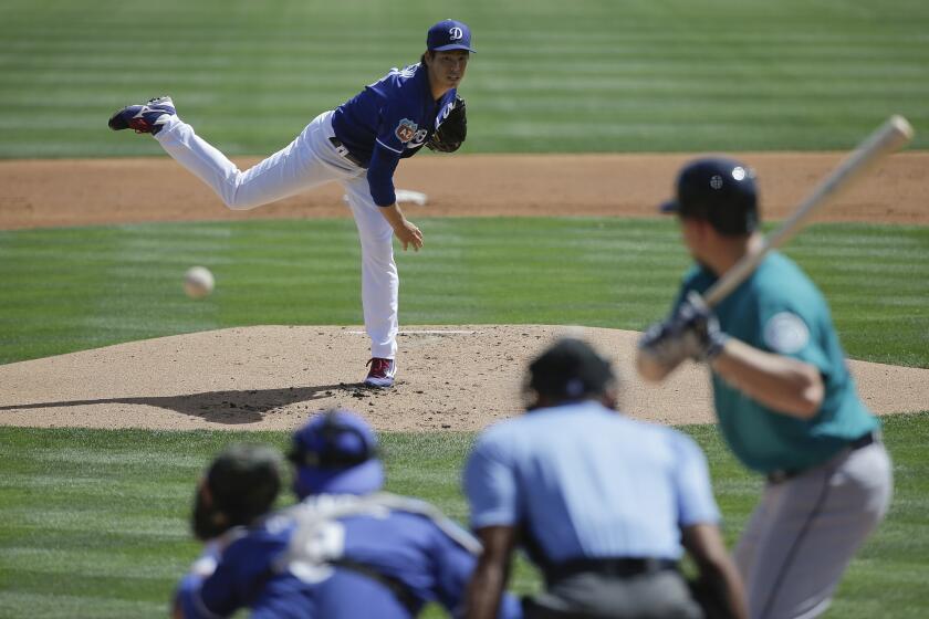Dodgers starting pitcher Kenta Maeda throws against the Mariners during the first inning of a spring training game.