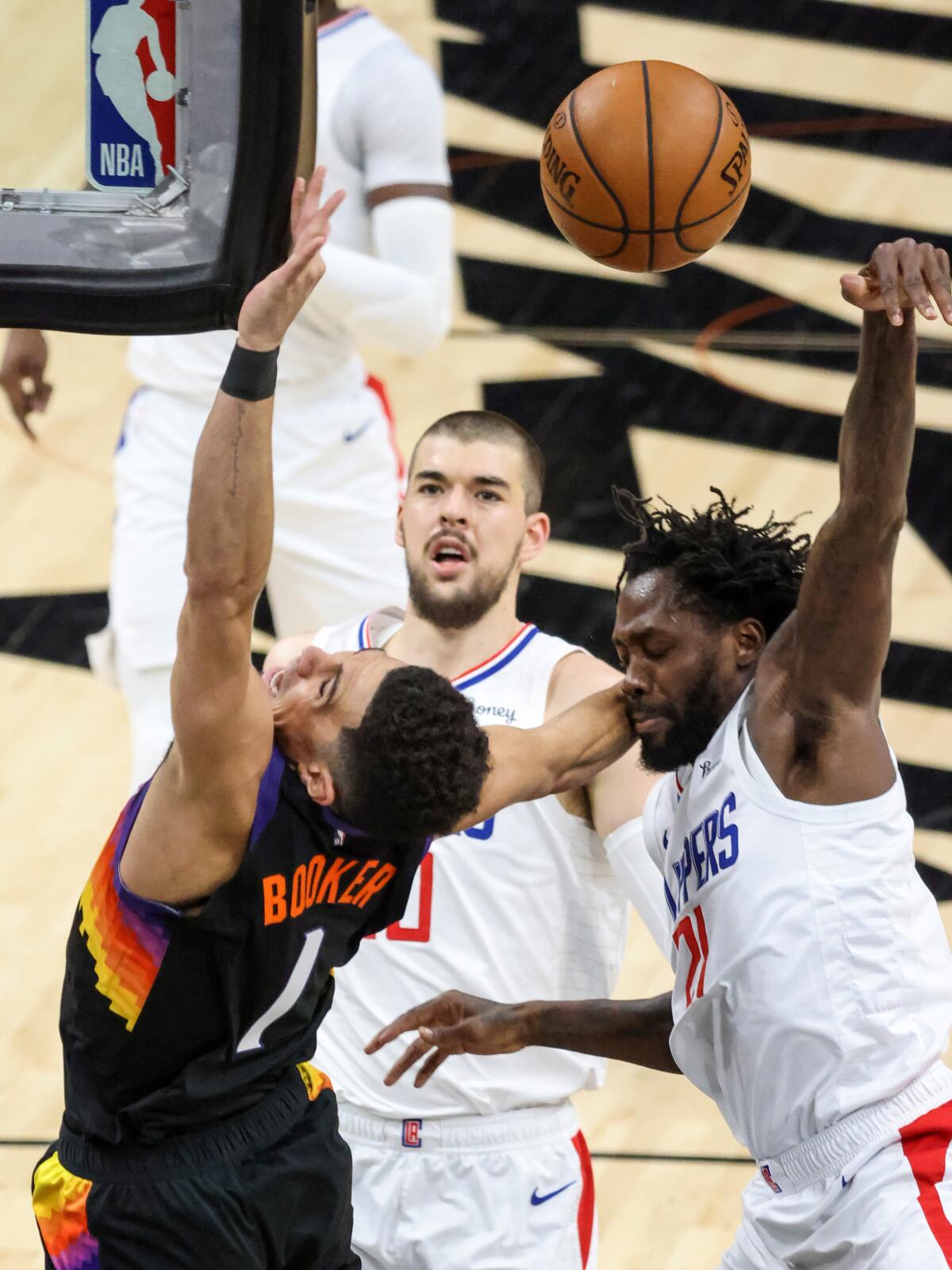 Suns guard Devin Booker (1) is fouled by Clippers guard Patrick Beverley.
