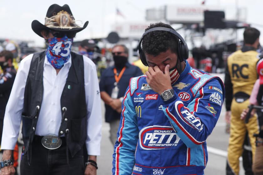 Driver Bubba Wallace, right, is overcome with emotion as he and team owner Richard Petty walk to his car in the pits of the Talladega Superspeedway prior to the start of the NASCAR Cup Series auto race at the Talladega Superspeedway in Talladega Ala., Monday June 22, 2020. In an extraordinary act of solidarity with NASCAR’s only Black driver, dozens of drivers pushed the car belonging to Bubba Wallace to the front of the field before Monday’s race as FBI agents nearby tried to find out who left a noose in his garage stall over the weekend. (AP Photo/John Bazemore)