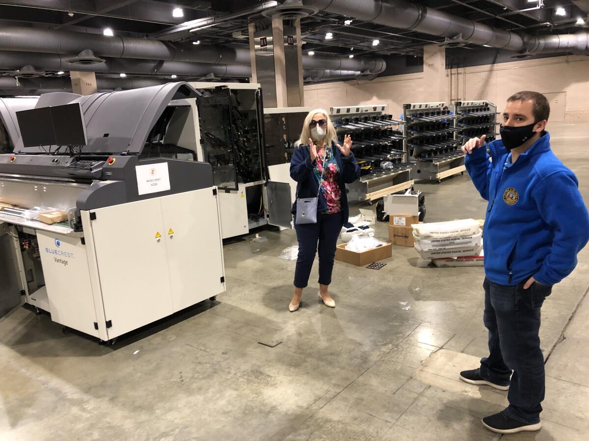 Lisa Deeley and Nick Custodio of Philadelphia's election commission next to the city's ballot-counting machinery.