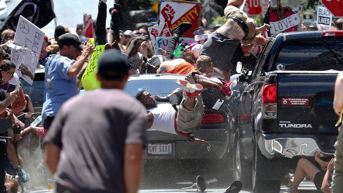 People fly into the air as a vehicle is driven into a group of protesters demonstrating against a white nationalist rally in Charlottesville, Va., on Aug. 12.