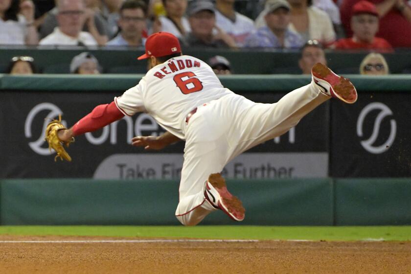 Los Angeles Angels' Anthony Rendon reaches for a double by Toronto Blue Jays' Vladimir Guerrero Jr. in the fifth inning of a baseball game Wednesday, Aug. 14, 2024, in Anaheim, Calif. (AP Photo/Jayne-Kamin-Oncea)