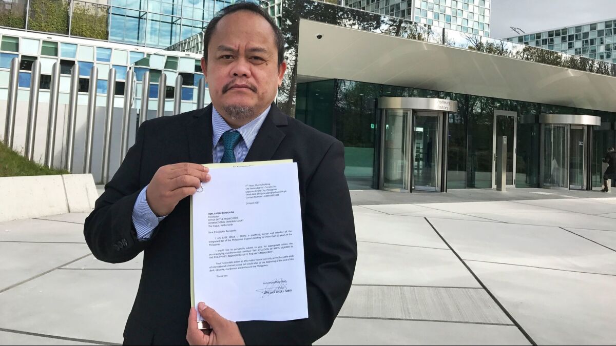Jude Sabio from the Philippines poses for a photo with his complaint against Philippine President Rodrigo Duterte outside the International Criminal Court in The Hague, Netherlands, on April 24.