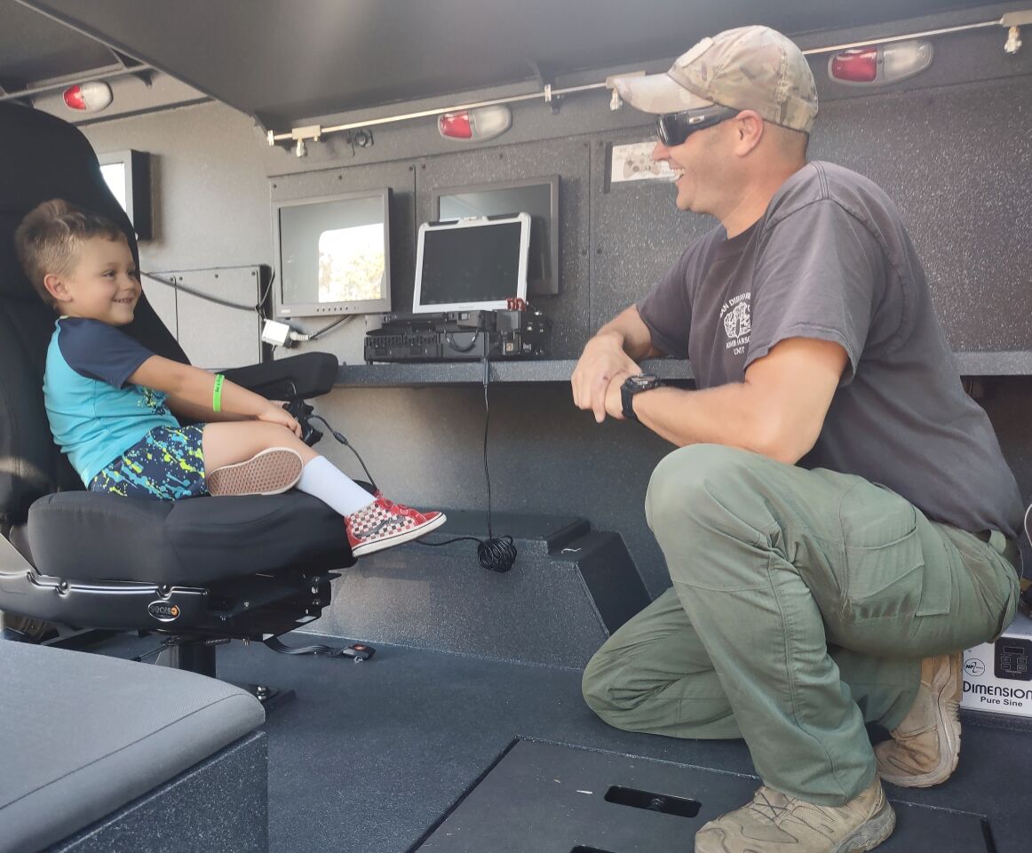Sheriff’s Department Bomb & Arson Unit Detective Anthony Tripoli gives a tour of his tactical response vehicle to Buddy Silva, 5.