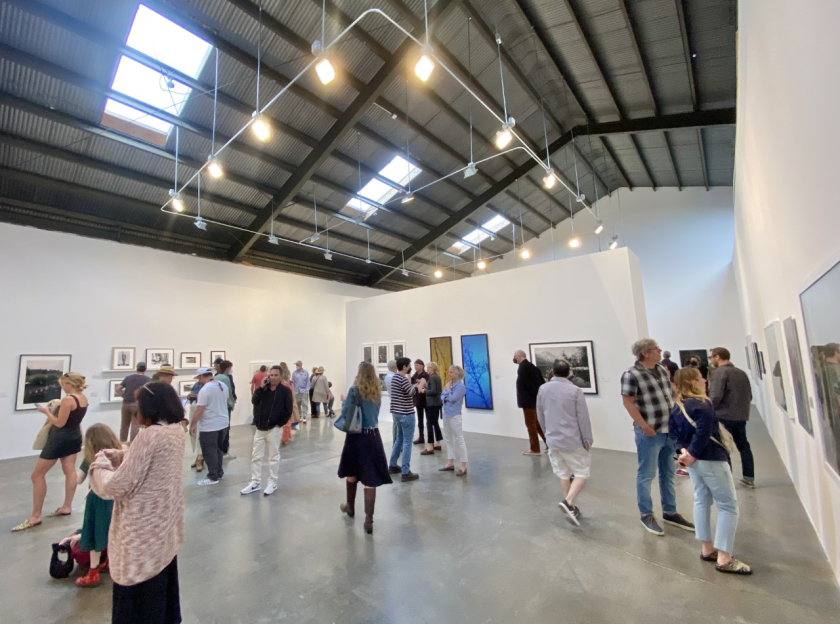 People mill about a gallery.