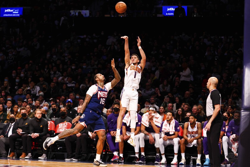 Phoenix Suns guard Devin Booker (1) shoots against Brooklyn Nets forward James Johnson (16) during the second half of an NBA basketball game, Saturday, Nov. 27, 2021, in New York. (AP Photo/Jessie Alcheh)