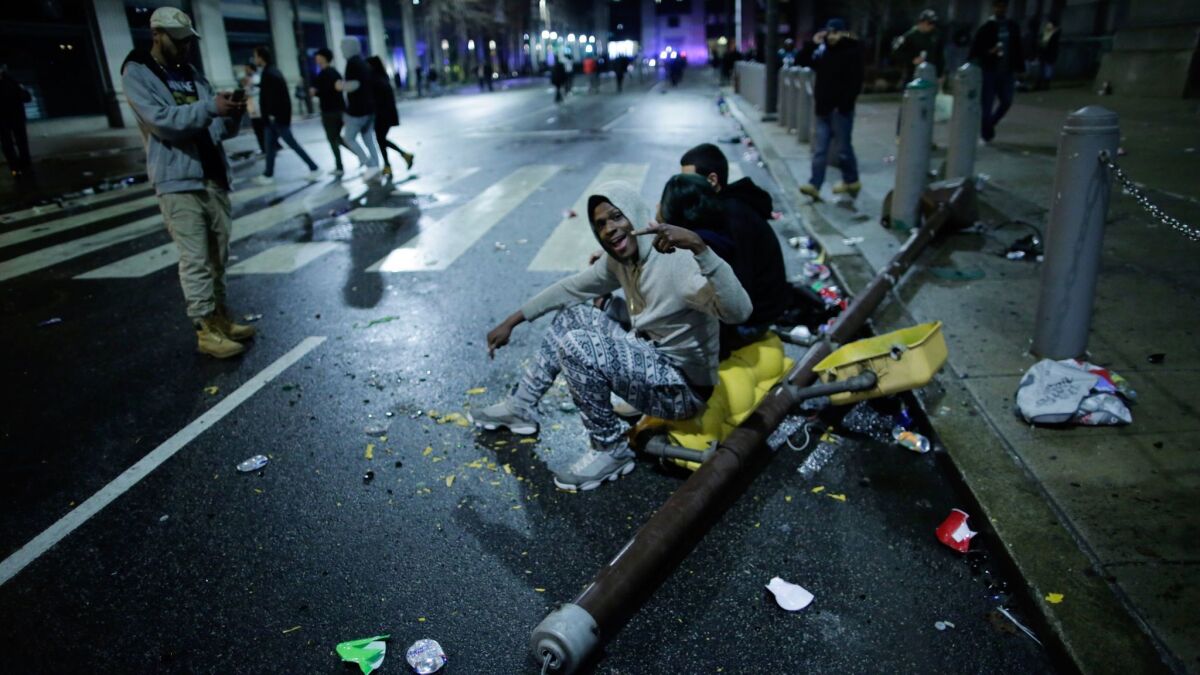 People sit on a felled traffic light pole while celebrating the Eagles' victory in Super Bowl LII in Philadelphia.