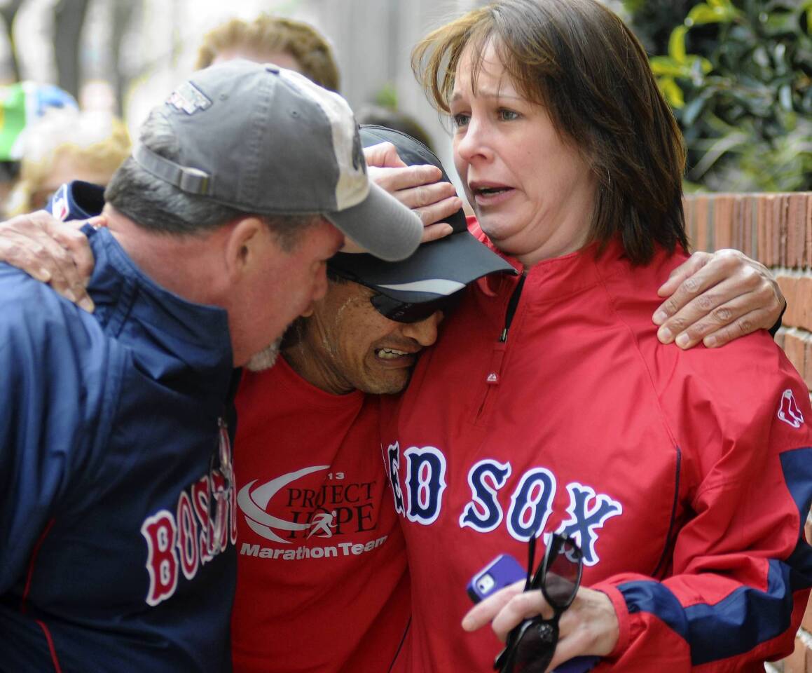 Runner John Ounao cries when he finds friends after several explosions rocked the finish of the Boston Marathon on April 15, 2013.