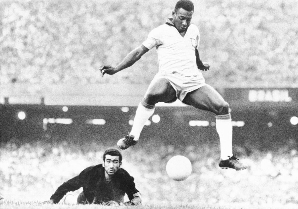 Pelé, right, scores past Venezuela goalkeeper Fabrizio Fasano, on the ground, in August 1969.