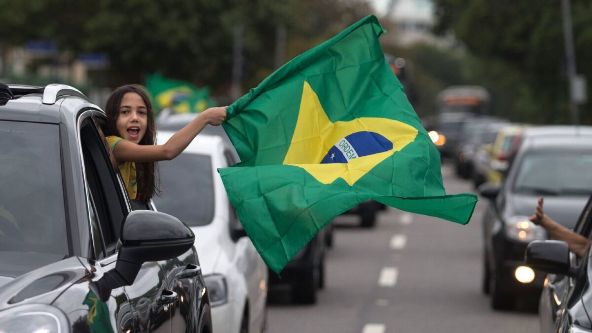 Supporters of presidential candidate Jair Bolsonaro cheer during general elections in front of the residential condominium where he lives in Rio de Janeiro on Sunday.