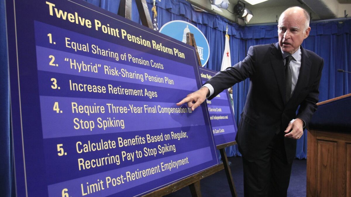 Then-Gov. Jerry Brown gestures to a chart in 2011 showing some of his proposals to roll back public employee pension benefits during a news conference at the state Capitol.