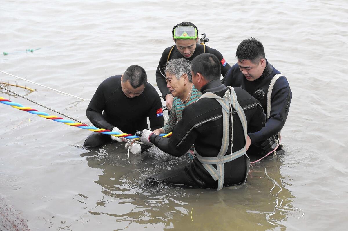A passenger is escorted to the Yangtze River bank after being rescued from the capsized Chinese cruise ship on June 2.