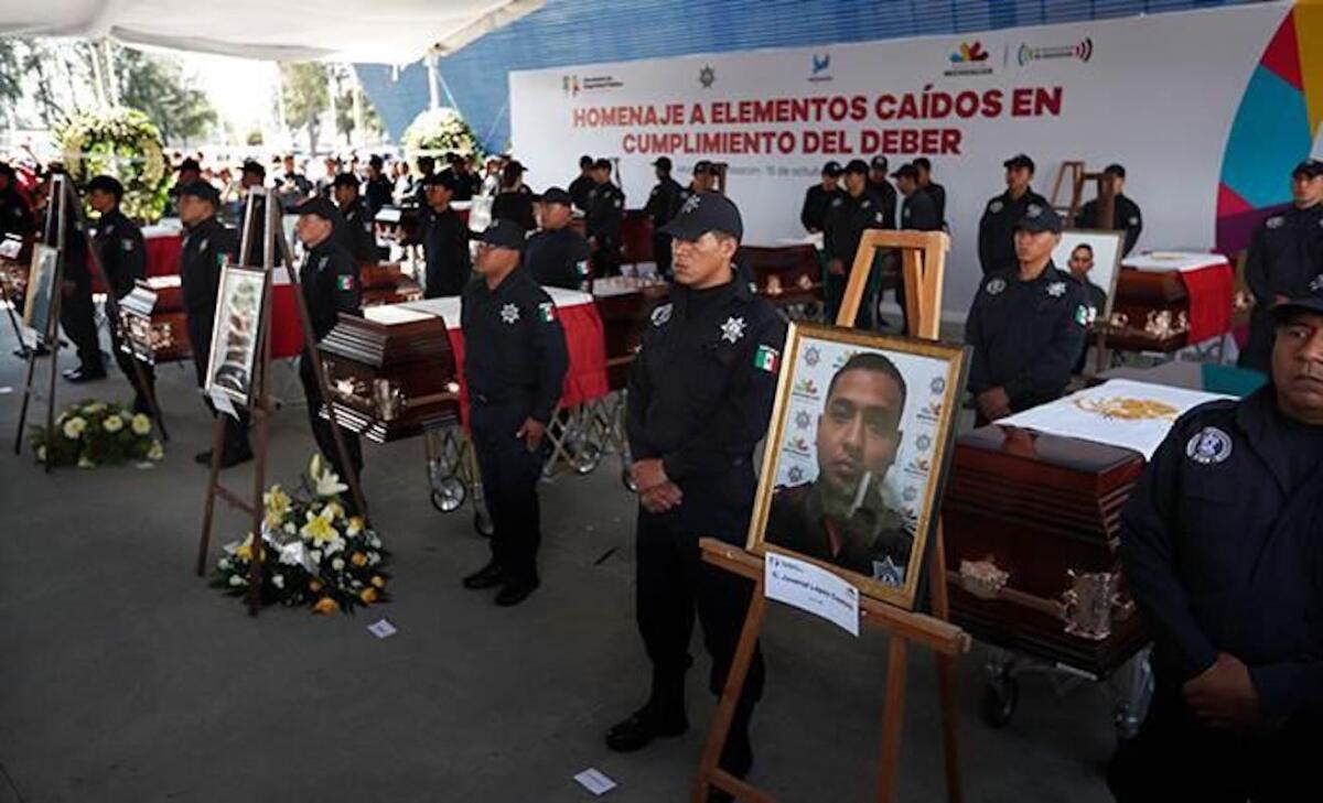 Agentes de la policía estatal de Michoacán junto a los ataúdes de sus colegas durante un funeral en la sede de la Secretaría de Seguridad Pública, en Morelia, México.