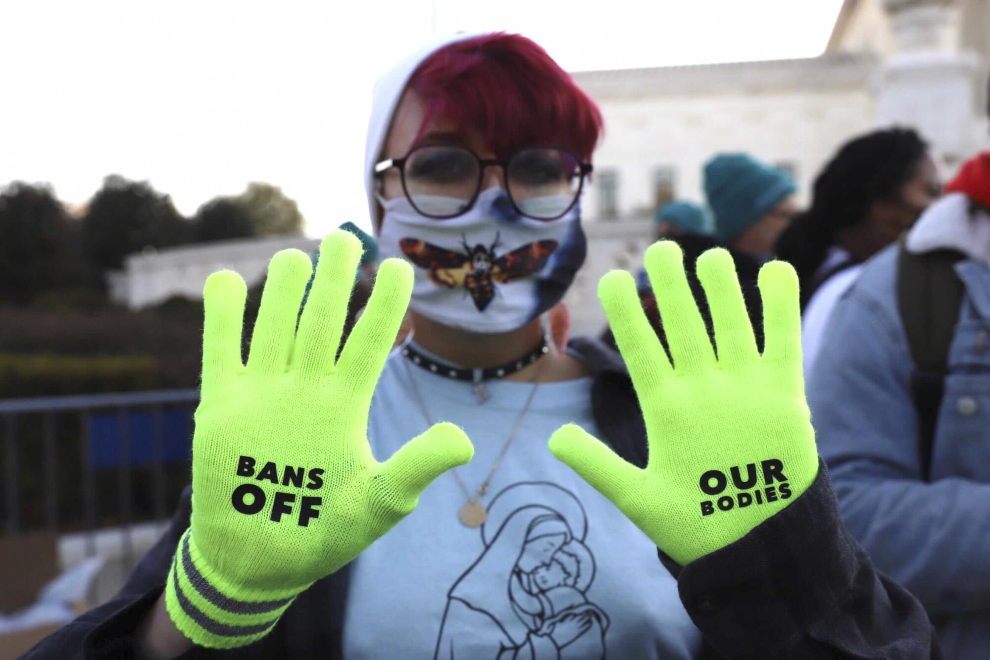 Jo Luttazi shows green gloves with "Bans Off Our Bodies" printed on them.