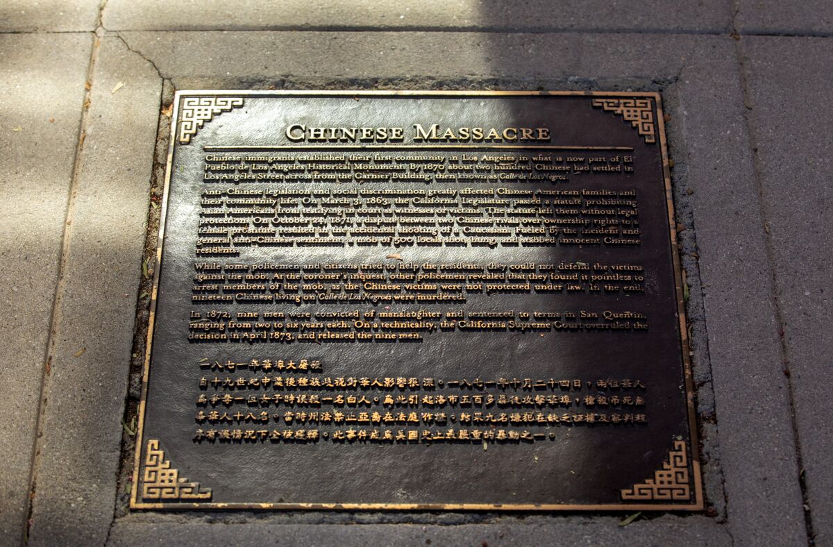 A plaque titled "Chinese Massacre" inlaid in a sidewalk