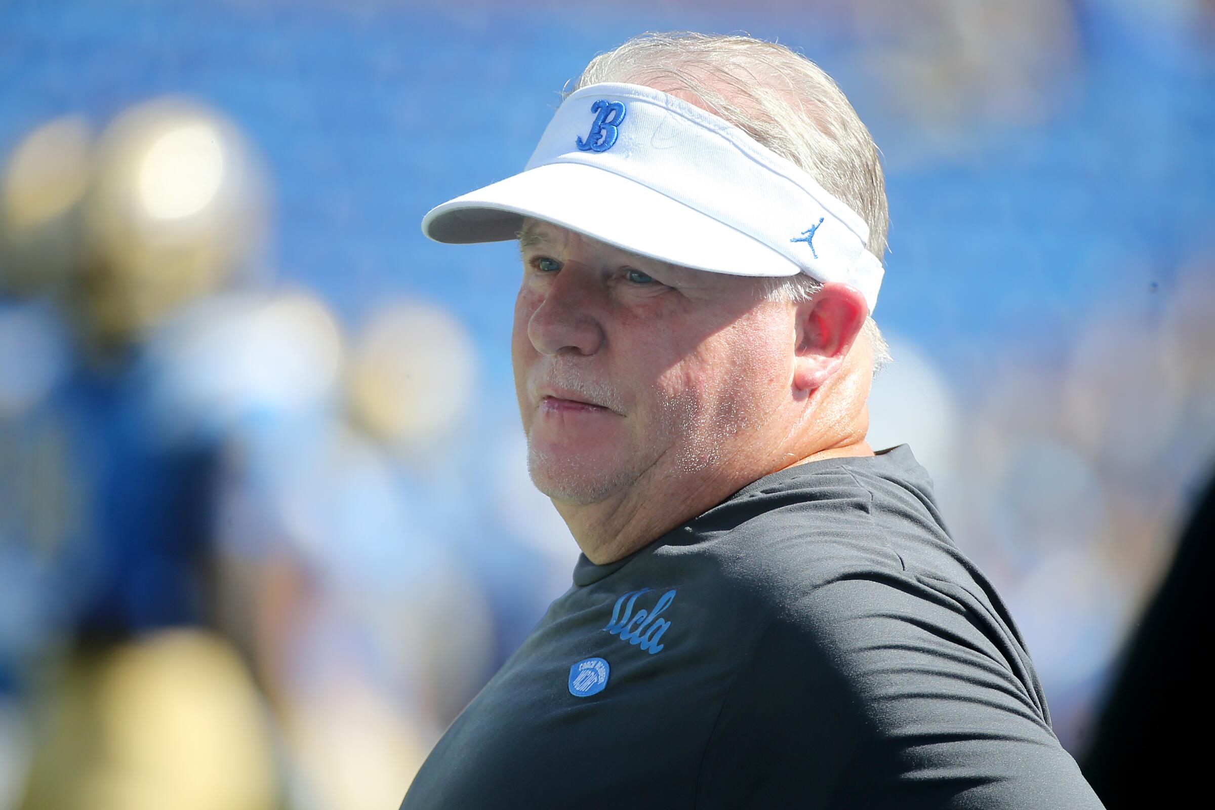 UCLA coach Chip Kelly watches his team warm up