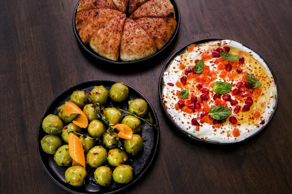 An overhead photo of mezze at the Brandy: labneh, marinated olives and fresh bread.