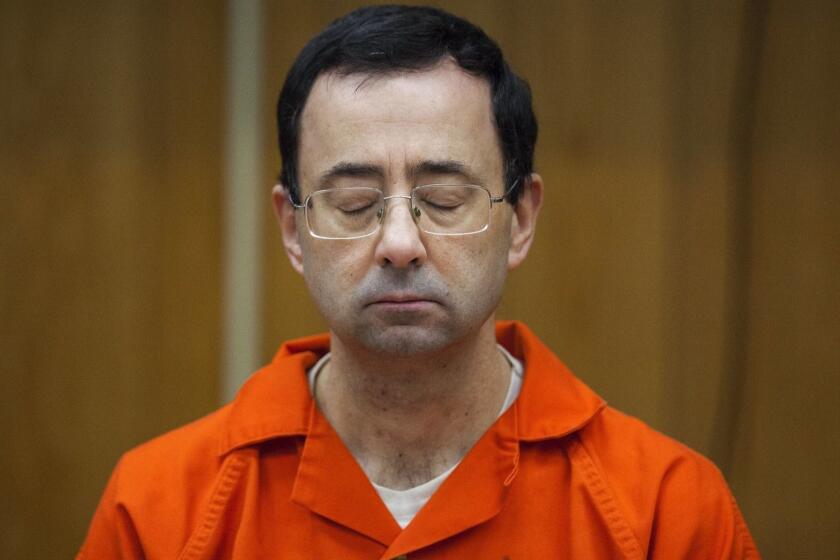 Larry Nassar listens during his sentencing at Eaton County Circuit Court in Charlotte, Mich., on Feb. 5, 2018. The former doctor for Michigan State University sports-medicine and USA Gymnastics received 40 to 125 years for three first degree criminal sexual abuse charges related to assaults at a gymnastics facility in Dimondale, Mich. Nassar has also been sentenced to 60 years in prison for three child pornography charges in federal court and between 40 to 175 years in Ingham County for seven counts of criminal sexual conduct. (Cory Morse/The Grand Rapids Press via AP)