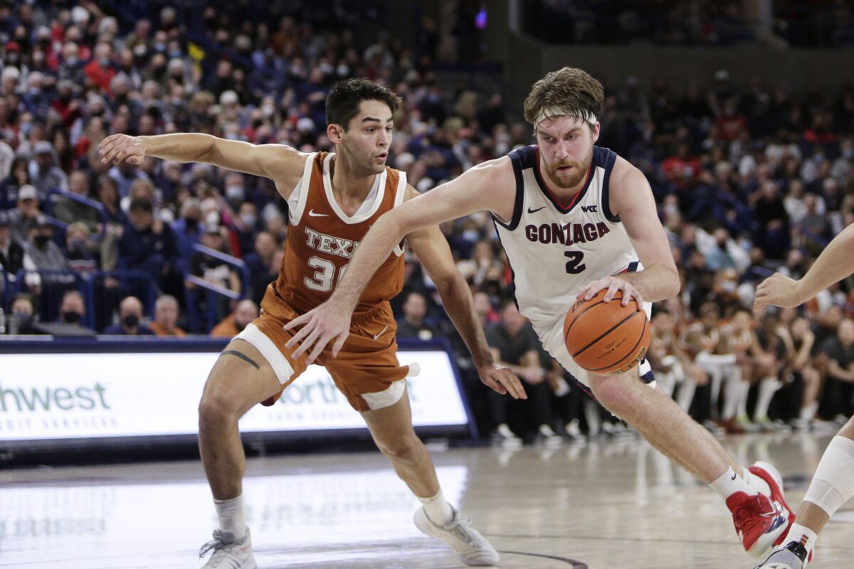 Gonzaga forward Drew Timme, right, drives to the basket while pressured by Texas forward Brock Cunningham during the second half of an NCAA college basketball game Saturday, Nov. 13, 2021, in Spokane, Wash. (AP Photo/Young Kwak)
