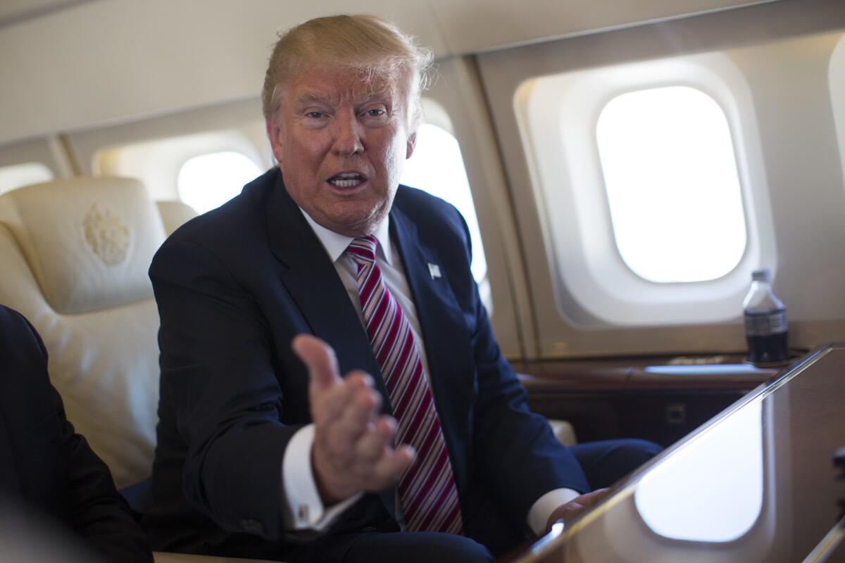 Donald Trump talks with reporters on his campaign plane.