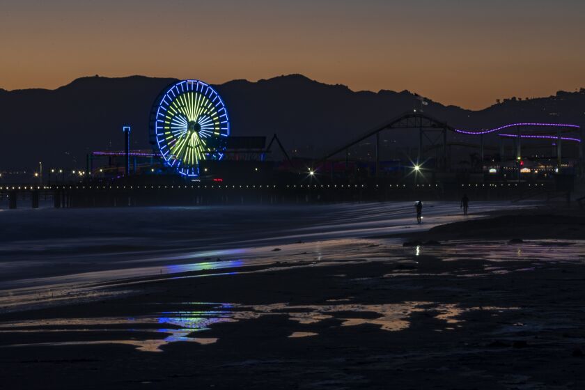 SANTA MONICA, CA - JULY 3, 2020: The Ferris wheel begins to change to patriotic colors as dusk sets in over the the pier on July 3, 2020 in Santa Monica, California. (Gina Ferazzi / Los Angeles Times)