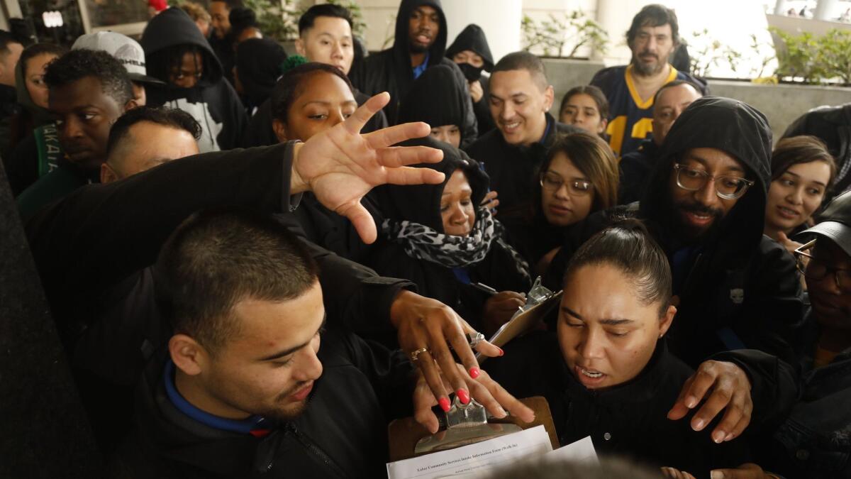 Transportation Security Administration employees try to get gift cards for groceries after an American Federation of Government Employees conference at LAX on Jan. 16. Other assistance is also being offered to furloughed workers during the government shutdown.