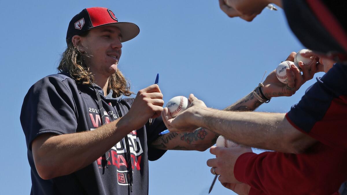 Cleveland Indians pitcher Mike Clevinger autographs baseballs for fans before an exhibition game against the Colorado Rockies on March 14.