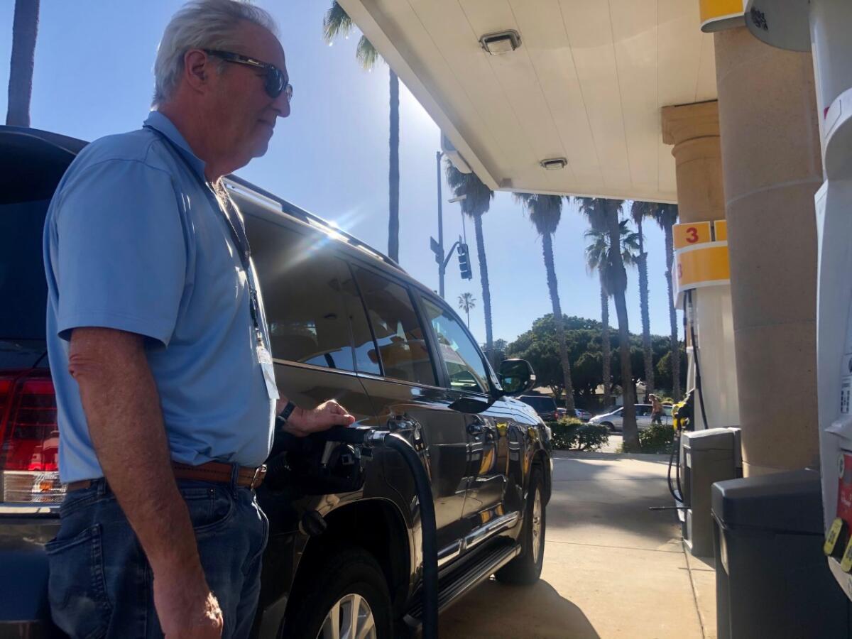 Guy Stone of La Jolla fills up the tank of his SUV at a Shell station. 