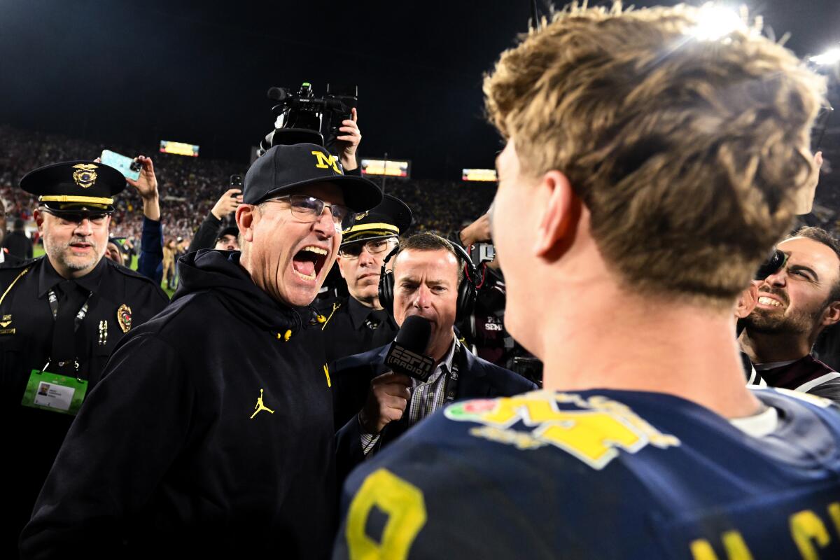 Michigan coach Jim Harbaugh (left) celebrates with quarterback J.J. McCarthy (9) after their Rose Bowl victory over Alabama.