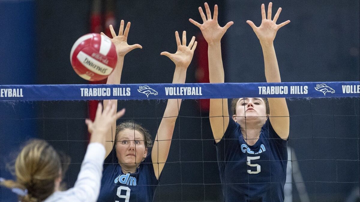 Corona del Mar High's Bella Pouliot (9) and Karly Recker (5) attempt to block a shot by Trabuco Hills' Kendall Anselmo in the quarterfinals of the CIF Southern Section Division 2 playoffs on Oct. 24.