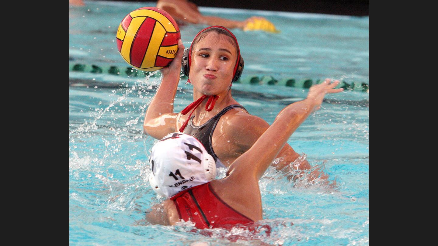 Quite determined to score, Burroughs' Aleah Orozco lines up a shot and shoots to score before Glendale's Emma Mueller gets to her in a Pacific League girls' water polo match at Burroughs High School on Thursday, January 19, 2017.