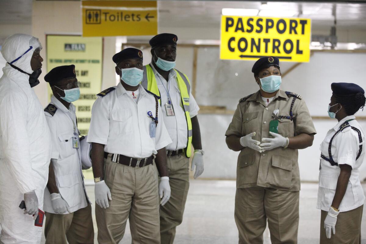 Nigerian health officials wait to screen passengers at the arrival hall of the international airport in Lagos earlier this month.