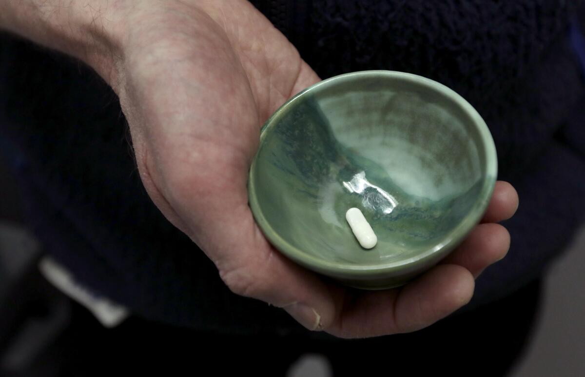 A ceramic bowl containing a white pill