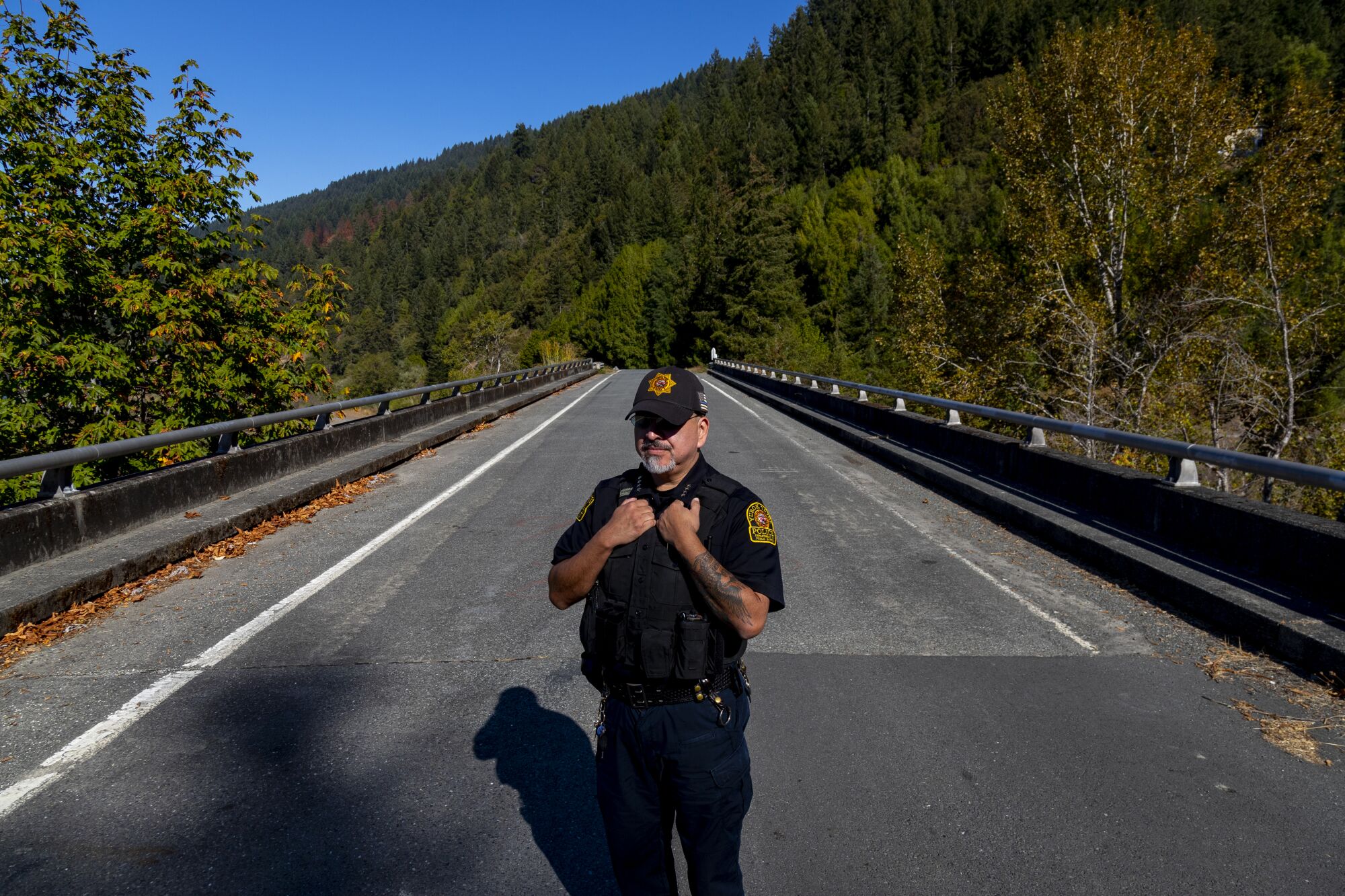 Yurok Tribal Police Chief Greg O'Rourke stands on a roadway bridge