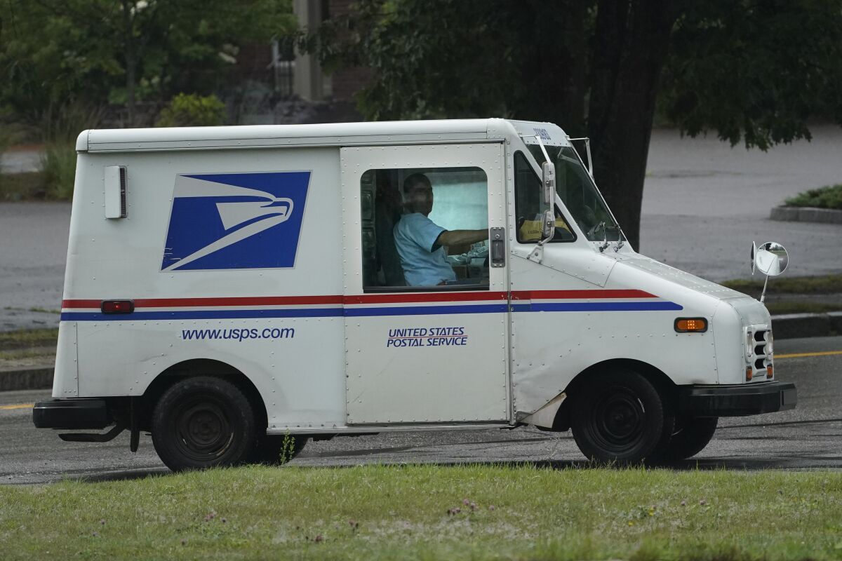U.S. Postal Service carrier John Graham drives a 28-year-old delivery truck while making's rounds, Wednesday, July 14, 2021, in Portland, Maine. Hundreds of the aging trucks were reported to catch fire in recent years. (AP Photo/Robert F. Bukaty)