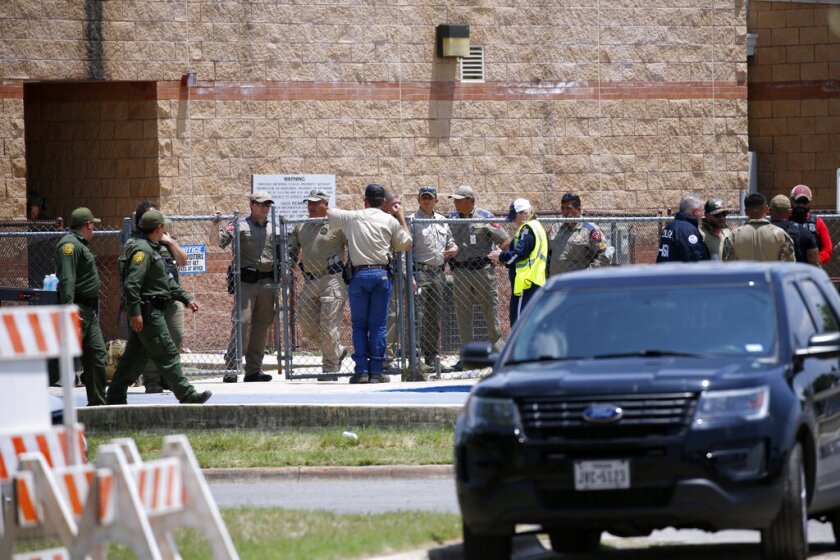 Policías y personal de emergencias se reúnen afuera de la Escuela Primaria Robb