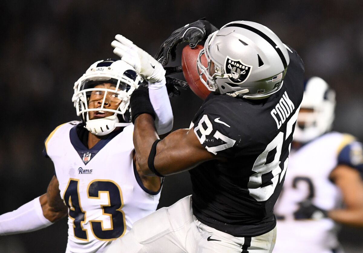 Oakland Raiders tight end Jared Cook makes a catch in front of Rams safety John Johnson in the first quarter at the Oakland Coliseum.