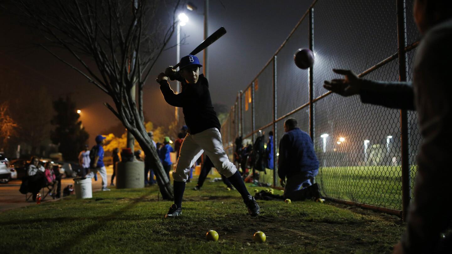 L.A. Bulldog Erik Baez, 12, hits baseballs against the perimeter fence surrounding the baseball field at Lemon Grove Recreation Center, where his team used to play inside the fence for free.