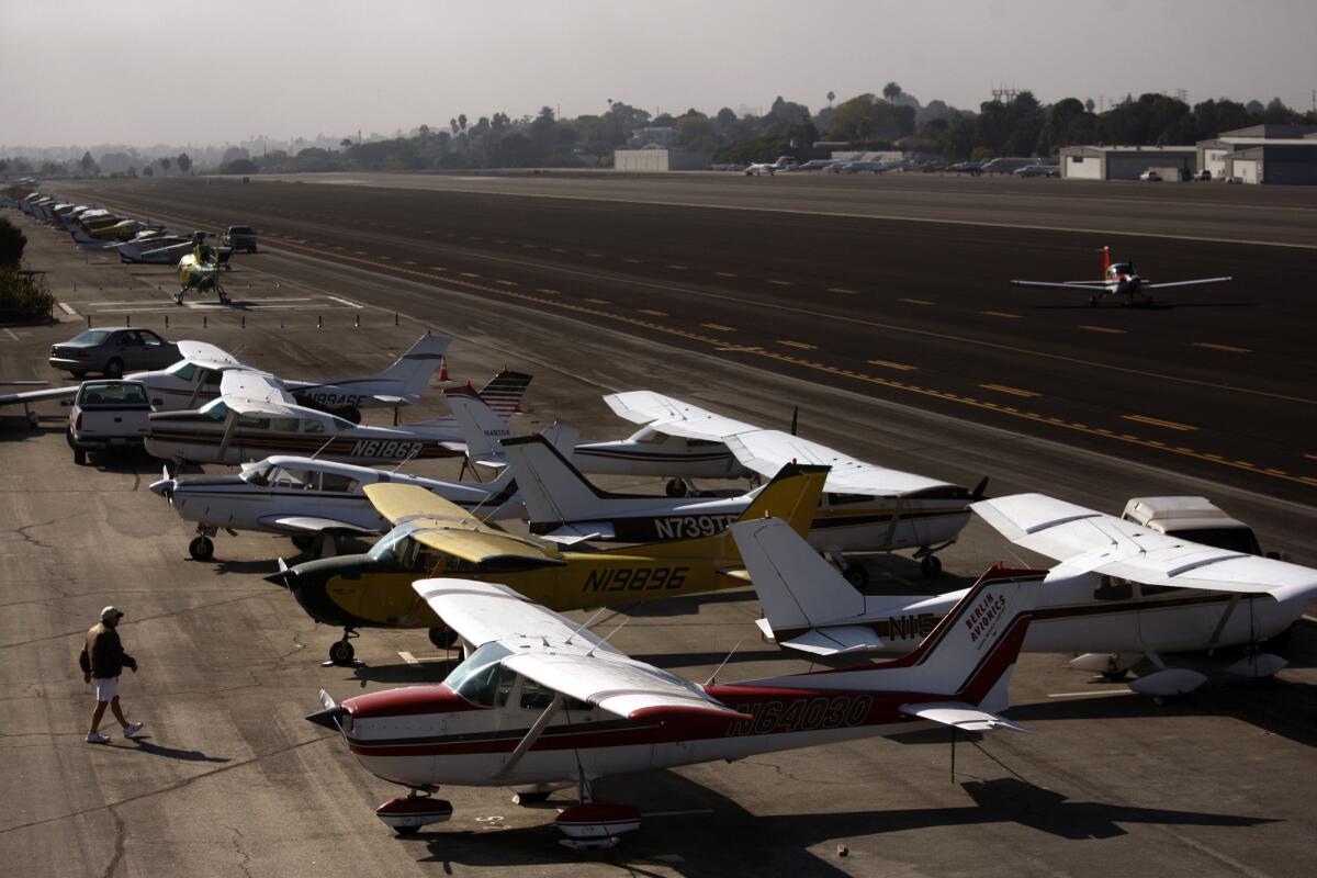 A man walks out onto the tarmac as a plane lands on the runway at the Santa Monica Airport. Community activists vowed to keep fighting to shut down the facility, despite a judge's dismissal of the city's lawsuit seeking ownership of the airport.