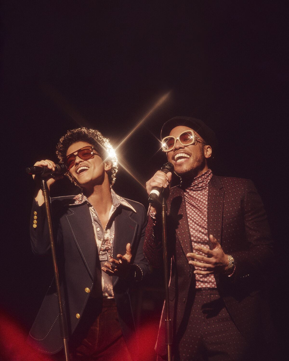 Two men dressed in retro suits singing into microphones