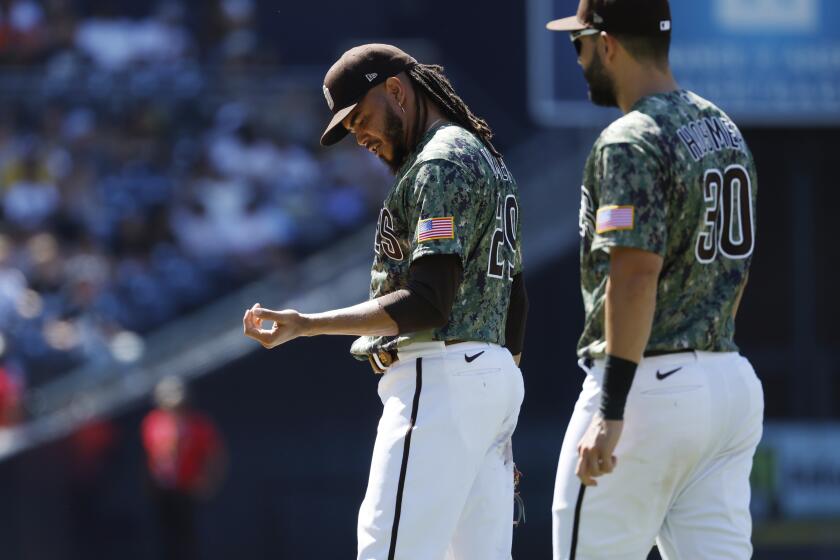 SAN DIEGO, CA - JULY 10: San Diego Padres pitcher Dinelson Lamet looks at his arm after fielding a hit by San Francisco Giants' Wilmer Flores in the eighth inning at Petco Park on Sunday, July 10, 2022 in San Diego, CA. (K.C. Alfred / The San Diego Union-Tribune)
