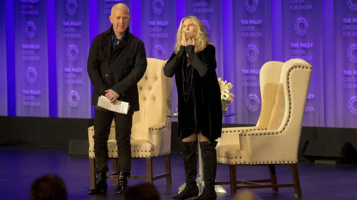 Barbra Streisand, with host Ryan Murphy, greets the audience on the first night of PaleyFest at the Dolby Theatre in Hollywood.
