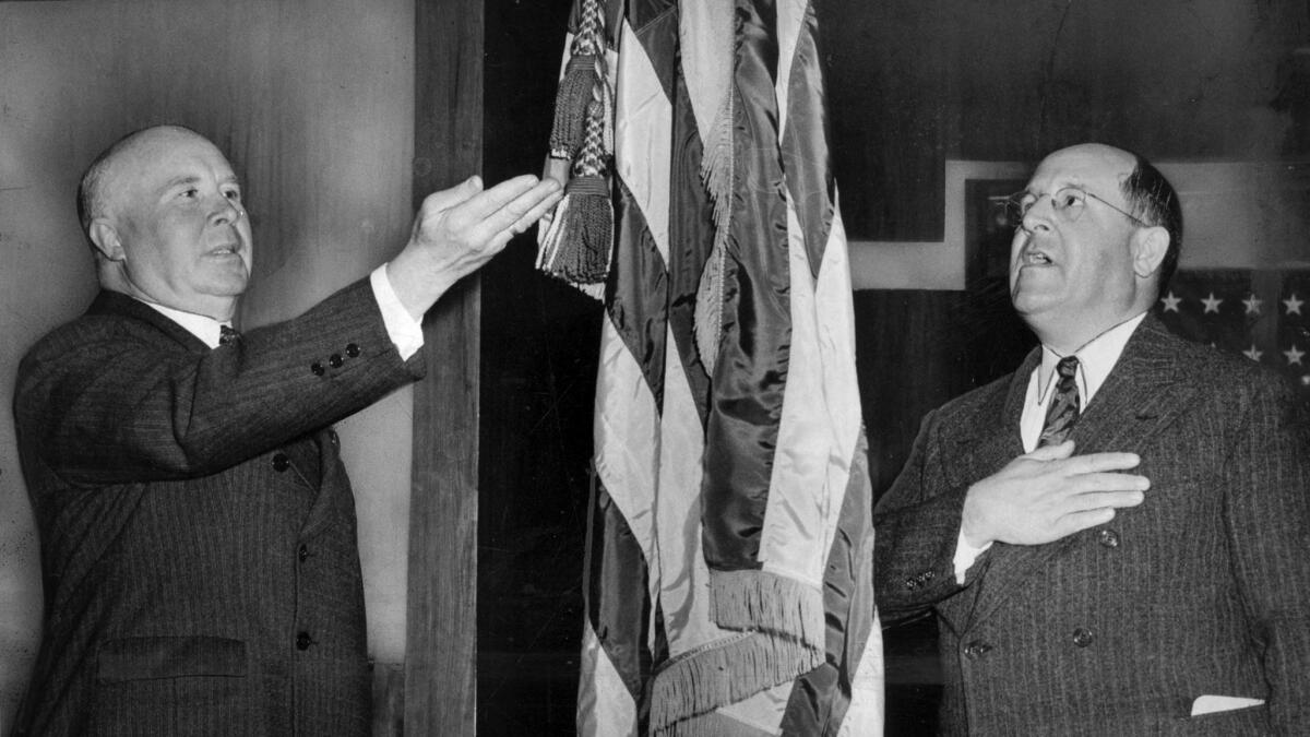 March 29, 1943: Vierling Kersey, superintendent of L.A. schools, left, and Roy J. Becker, Board of Education president, demonstrate old and new methods of saluting Old Glory. 