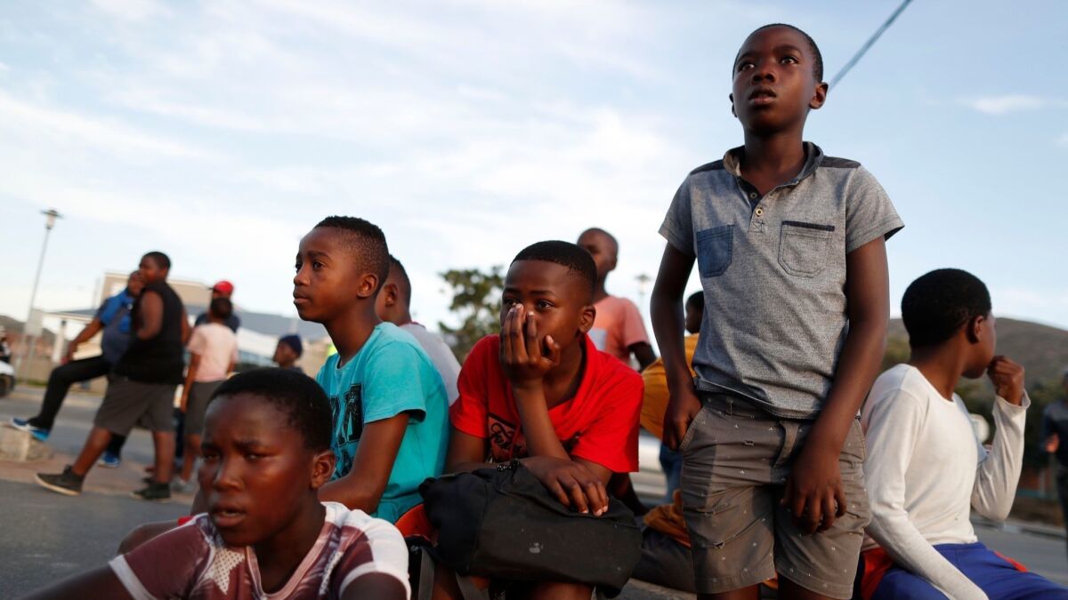 Children watch a soccer game in a park in Masiphumelele, Cape Town, South Africa. With five African teams at the World Cup, excitement mounts.