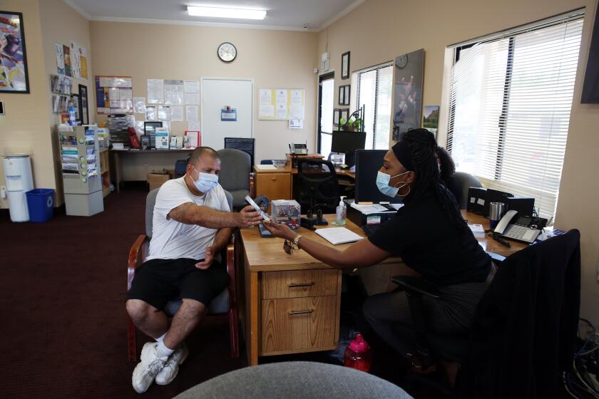 HESPERIA, CA - AUGUST 25: Domingo Nunez, left, speaks with Brittany Johnson Thompson, right, at the Victor Valley Resource center to learn ways he can raise his credit score in San Bernardino on Tuesday, Aug. 25, 2020 in Hesperia, CA. Nunez was released from prison three years ago and finding housing has been extremely challenging due to crime free housing policies. (Dania Maxwell / Los Angeles Times)
