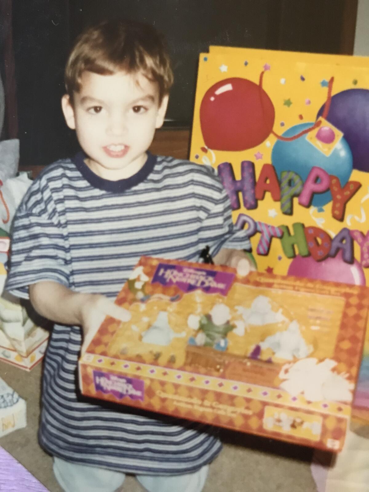 A boy holds a gift in a birthday photo