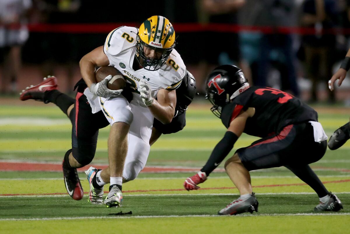 Edison receiver Tucker Tripp (2) breaks tackles and runs upfield during Friday's game at San Clemente.