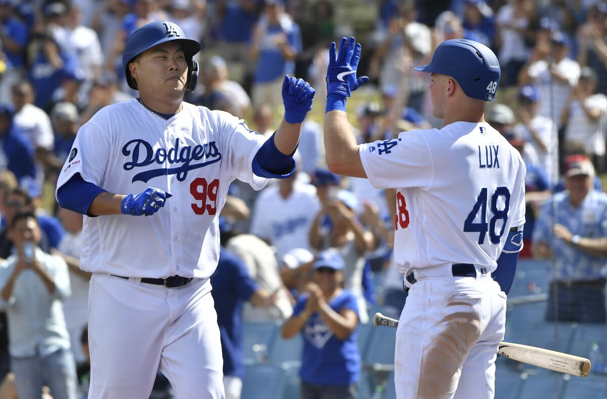 Dodgers pitcher Hyun-Jin Ryu, left, is congratulated by teammate Gavin Lux after hitting the first home run of his career.