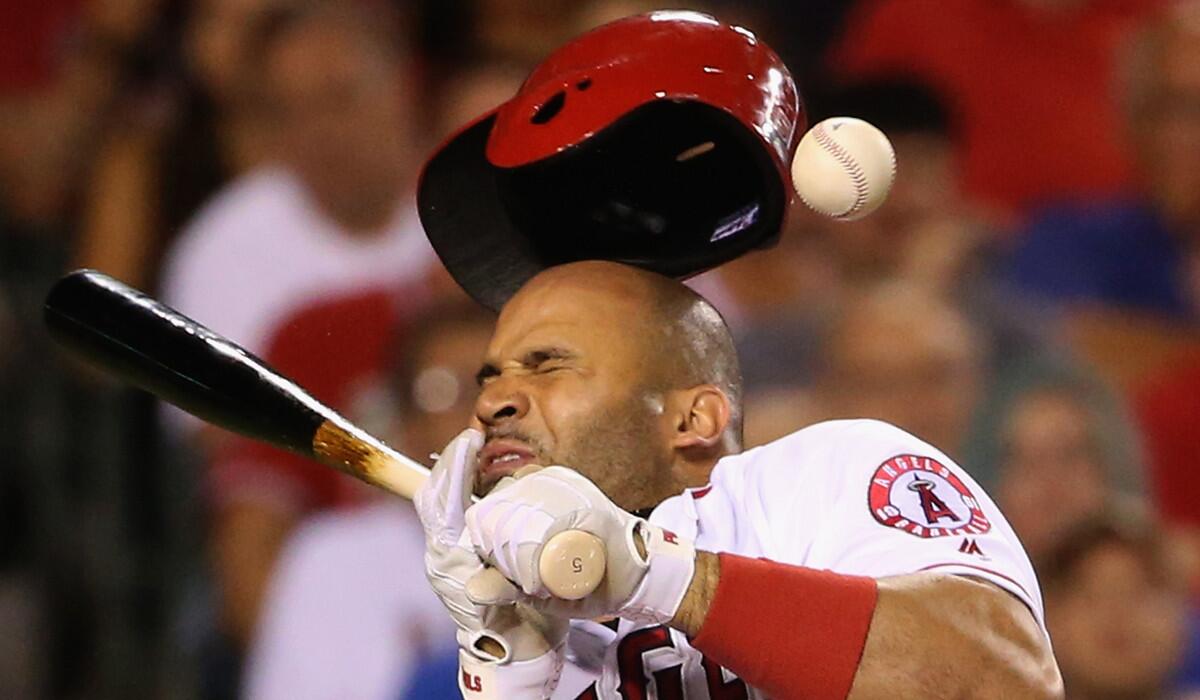 Angels' Albert Pujols reacts to being hit in the head by a pitch from Texas Rangers pitcher Tony Barnette during the seventh inning on Tuesday.