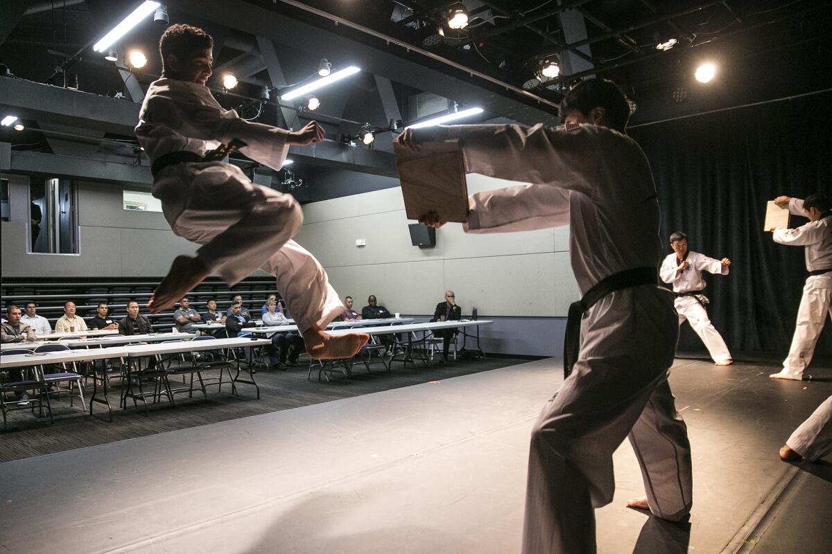 LAPD officers look on as the Xplore Taekwondo Demonstration Team performs during a daylong seminar on Korean culture at the Korean Cultural Center.